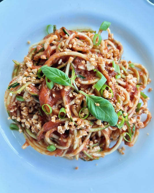 Raw vegan pasta with sauce and cheese